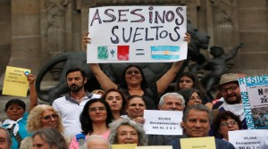 A woman who is part of the Argentinan community in Mexico holds a sign during a demonstration in Mexico City